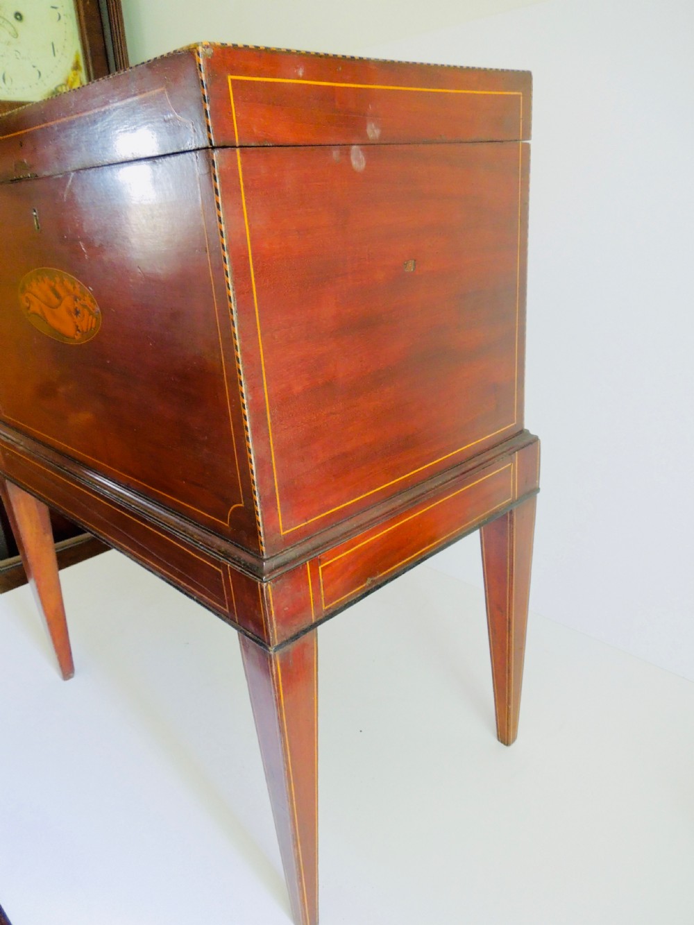 A Georgian mahogany wine cooler on square tapered legs featuring fine boxwood stringing and a central shell inlay medallion. View VI