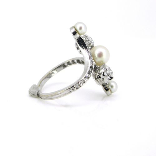 fig 2. An Edwardian platinum and white gold crossover ring set with central natural pearls and round diamonds along curved shoulders.