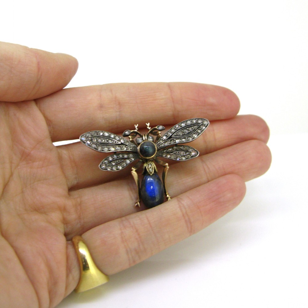 An antique fly brooch and pendant crafted from yellow gold and silver, set with small diamonds across the wings and a polished cabochon labradorite body. View VIII