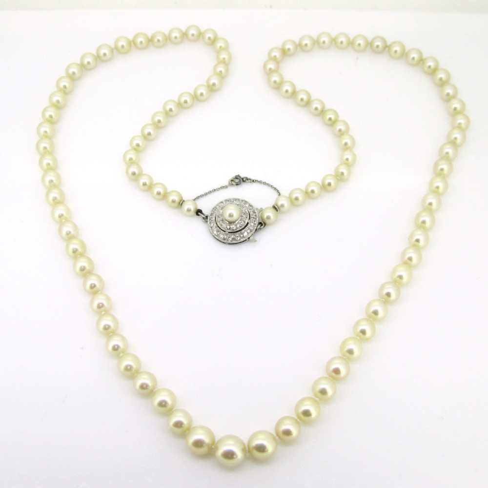 A single strand of cream cultured pearls featuring a circular diamond-set 18ct white gold clasp with a safety chain. View III