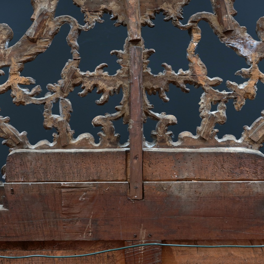 An 18th-century silvered Rococo overmantel mirror featuring an elaborately carved crest with C-scrolls and a tripartite mirror plate with visible foxing. View XIX