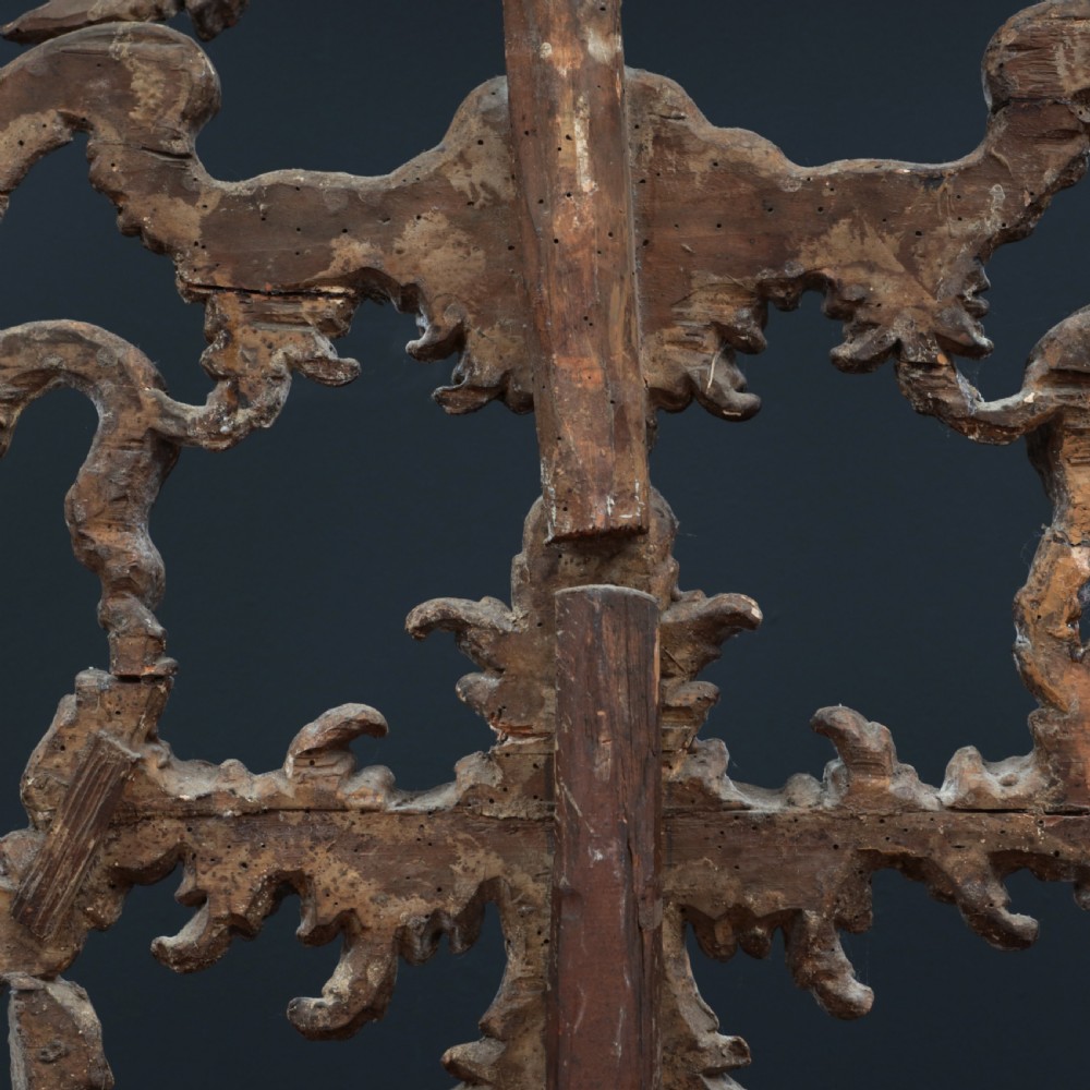 An 18th-century silvered Rococo overmantel mirror featuring an elaborately carved crest with C-scrolls and a tripartite mirror plate with visible foxing. View XXII