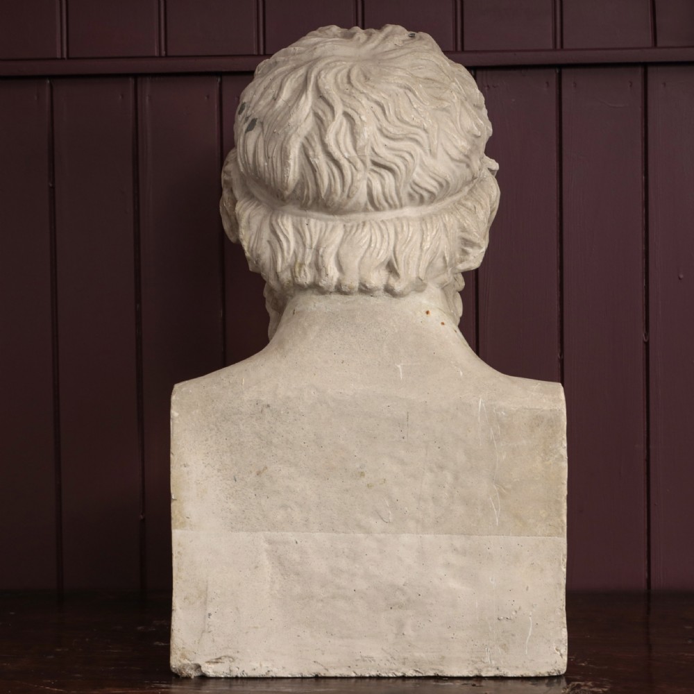 An off-white plaster bust depicting the classical Greek poet Homer with a detailed curly beard and headband, set on a flat square base. View X