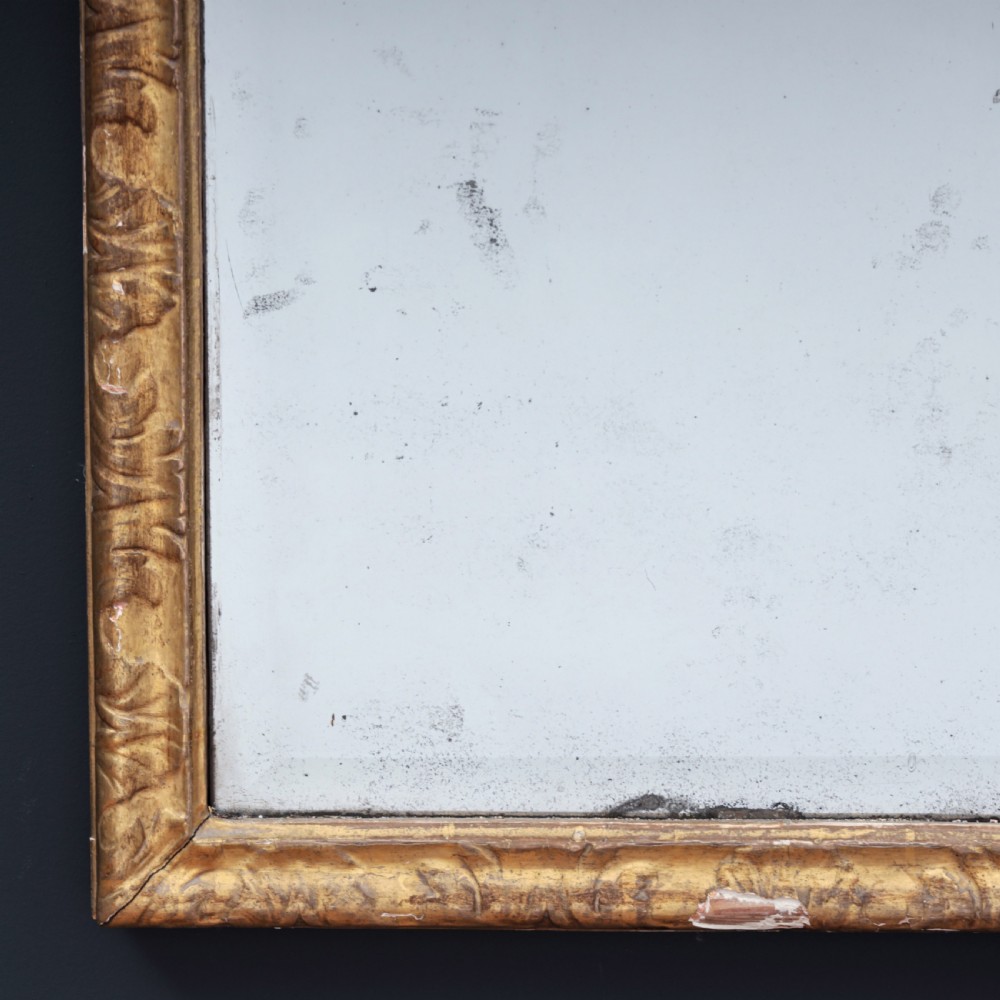 A tall George I period giltwood wall mirror featuring an ornate carved crown cresting, shell motif, and a two-section mirror plate. View V