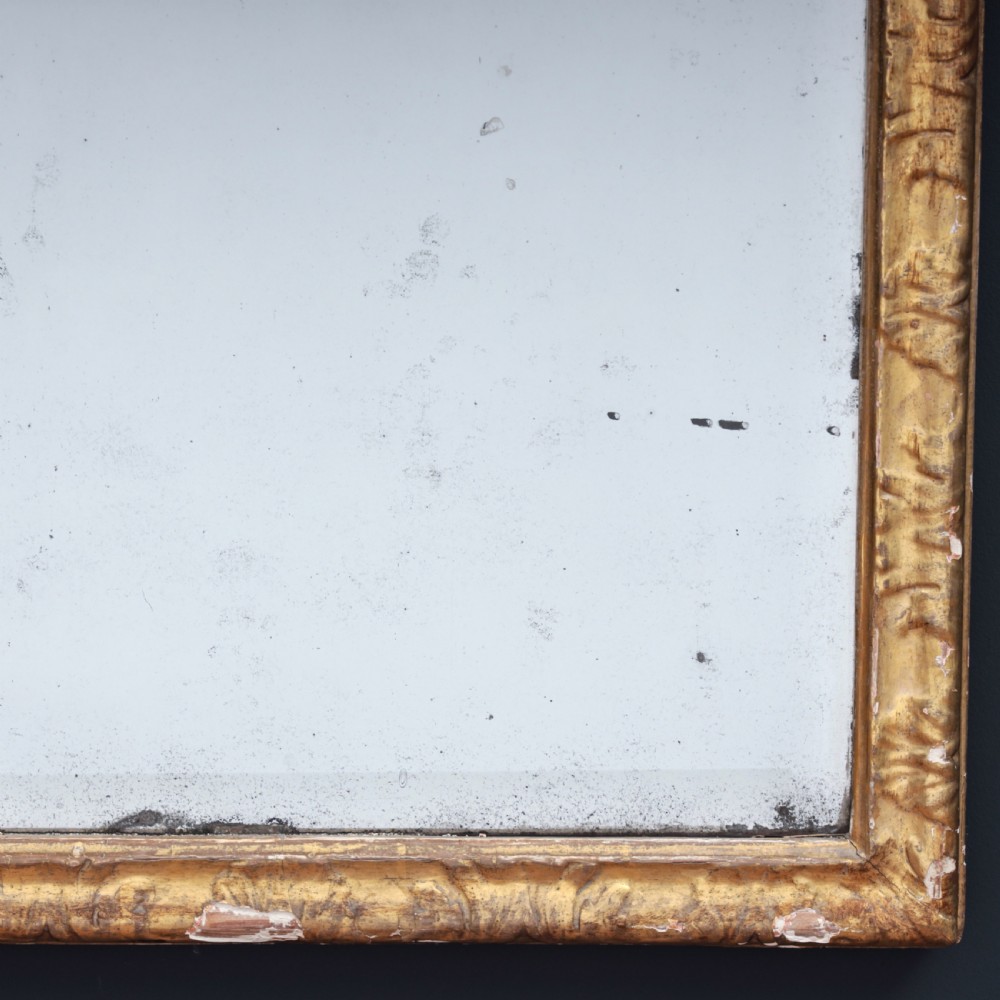 A tall George I period giltwood wall mirror featuring an ornate carved crown cresting, shell motif, and a two-section mirror plate. View VI