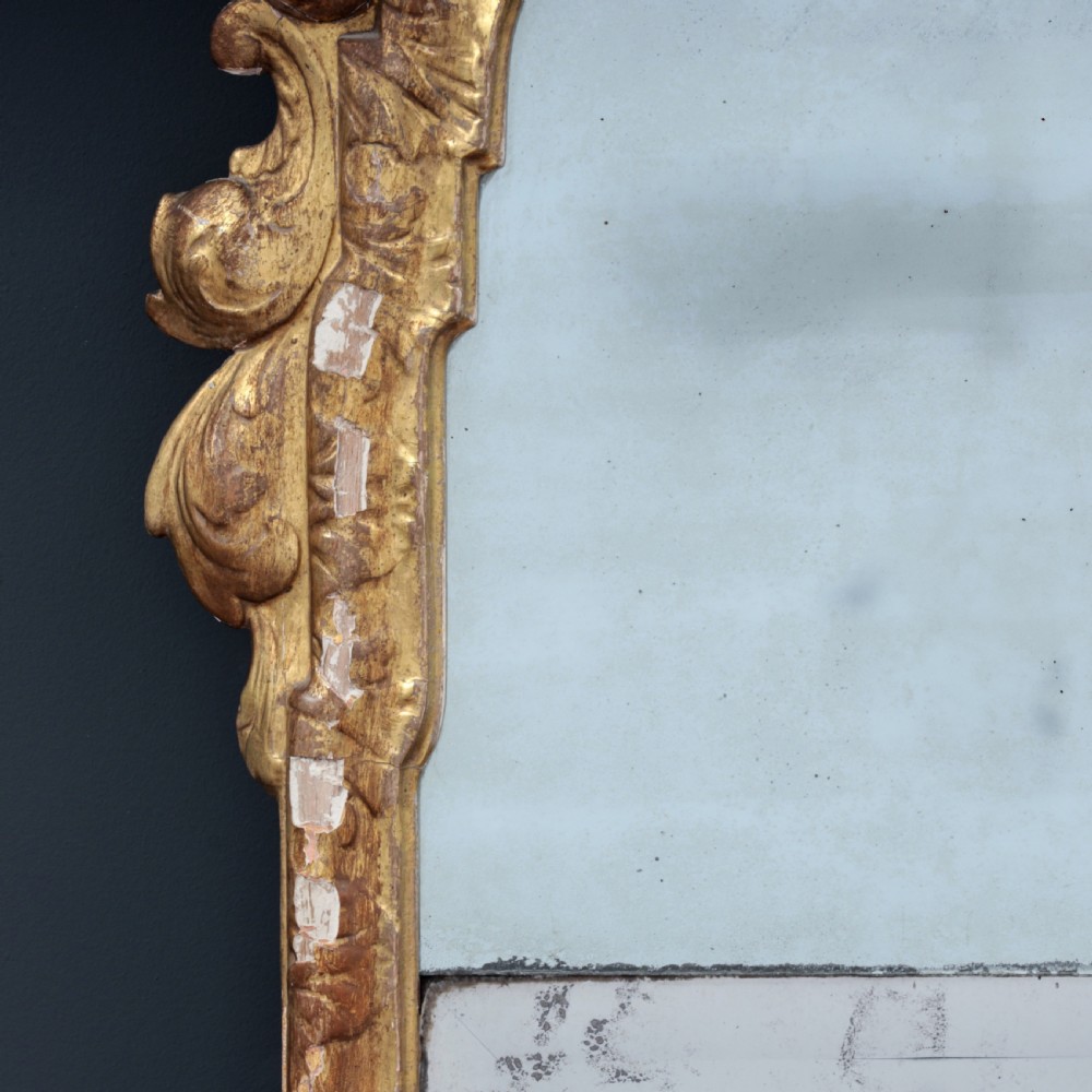 A tall George I period giltwood wall mirror featuring an ornate carved crown cresting, shell motif, and a two-section mirror plate. View VIII