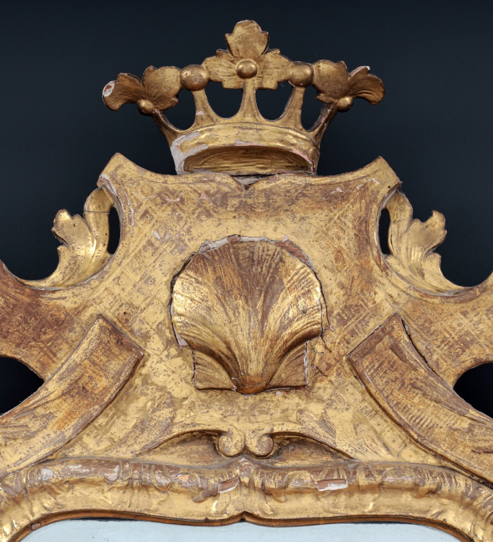 A tall George I period giltwood wall mirror featuring an ornate carved crown cresting, shell motif, and a two-section mirror plate. View IX