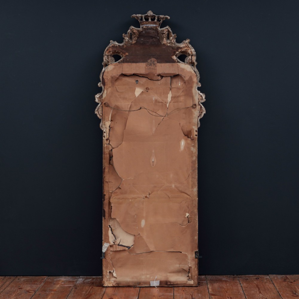 A tall George I period giltwood wall mirror featuring an ornate carved crown cresting, shell motif, and a two-section mirror plate. View X