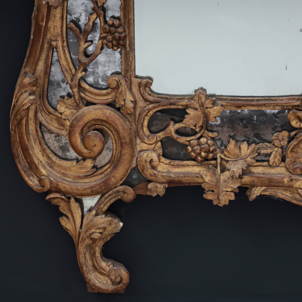 An ornate Louis XV style gilded mirror featuring a carved timber frame with vine motifs and a flower basket crest. View VII