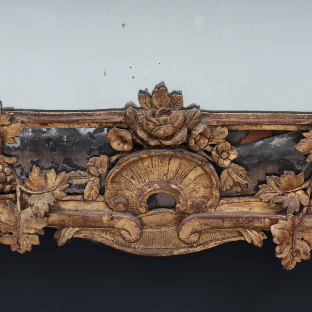 An ornate Louis XV style gilded mirror featuring a carved timber frame with vine motifs and a flower basket crest. View VIII