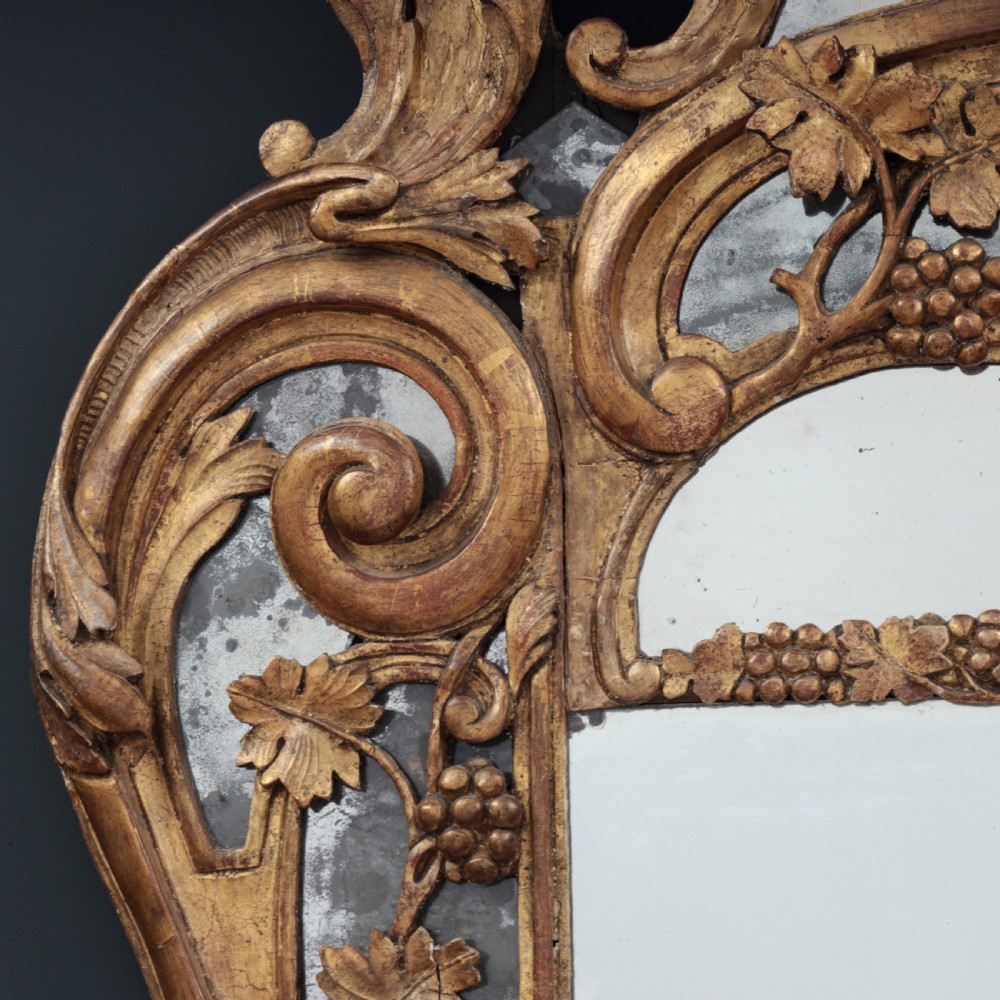 An ornate Louis XV style gilded mirror featuring a carved timber frame with vine motifs and a flower basket crest. View X