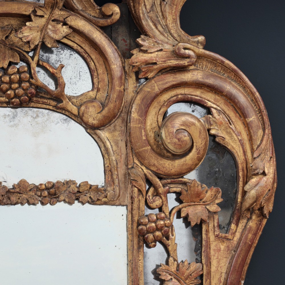 An ornate Louis XV style gilded mirror featuring a carved timber frame with vine motifs and a flower basket crest. View XI
