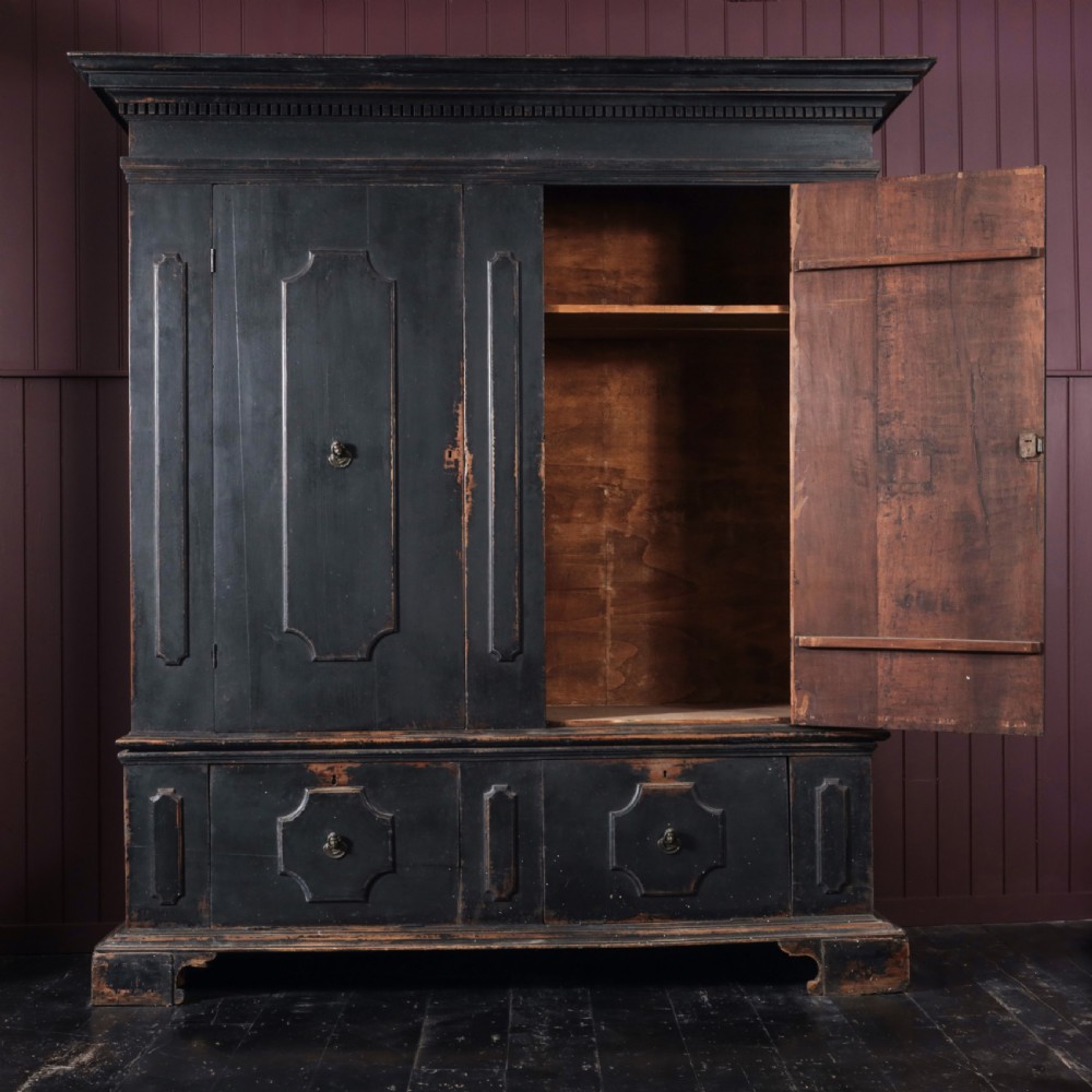 An 18th-century Tuscan cabinet featuring a distressed black painted finish, moulded cornice, panelled double doors, and lower drawers on bracket feet. View II