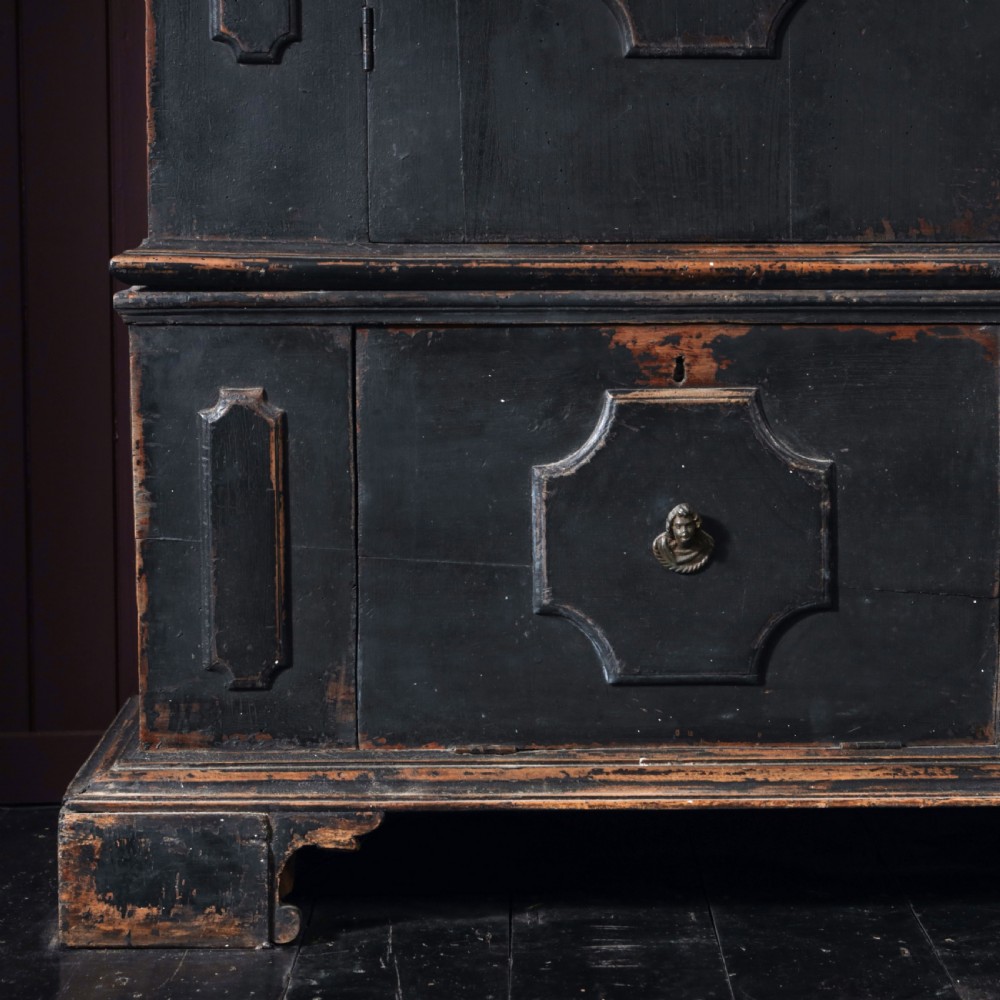 An 18th-century Tuscan cabinet featuring a distressed black painted finish, moulded cornice, panelled double doors, and lower drawers on bracket feet. View VI