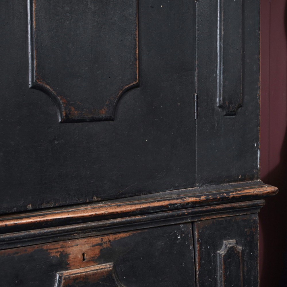 An 18th-century Tuscan cabinet featuring a distressed black painted finish, moulded cornice, panelled double doors, and lower drawers on bracket feet. View IX