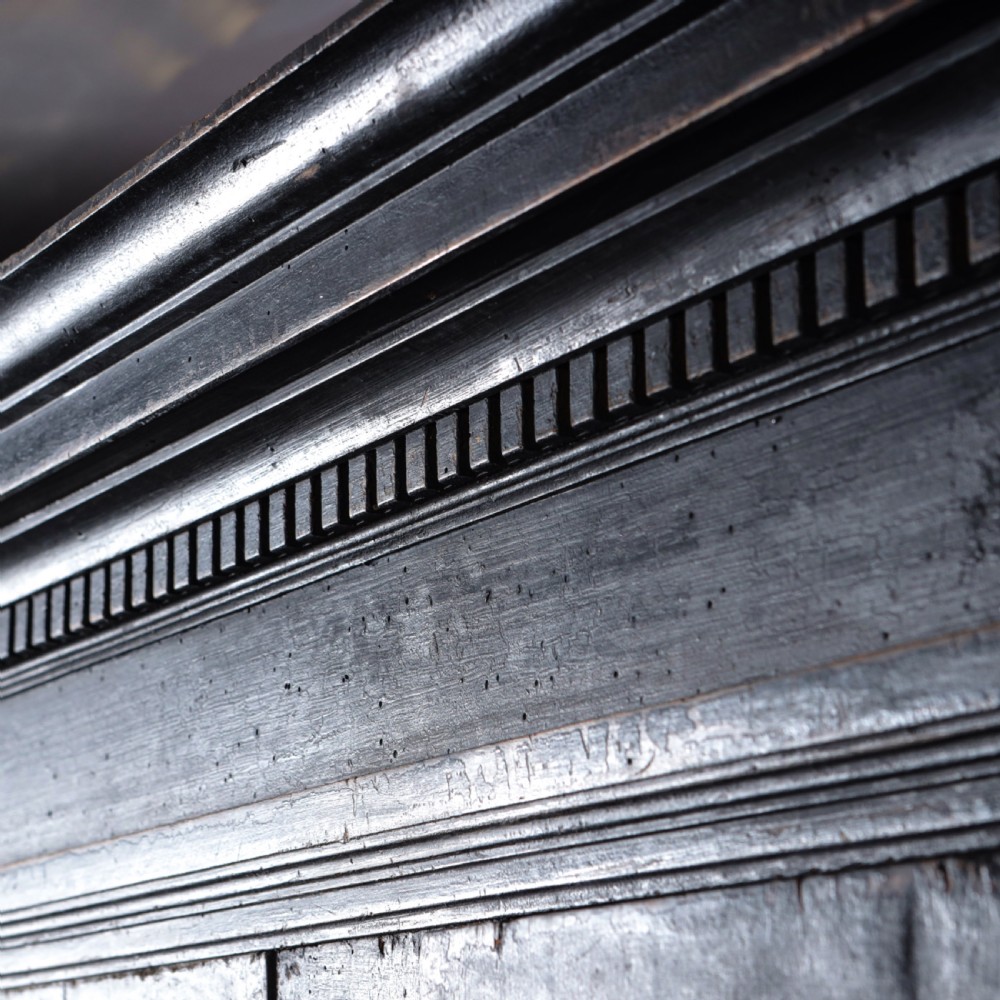 An 18th-century Tuscan cabinet featuring a distressed black painted finish, moulded cornice, panelled double doors, and lower drawers on bracket feet. View XII
