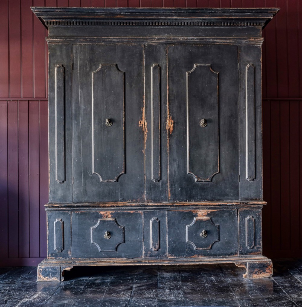 An 18th-century Tuscan cabinet featuring a distressed black painted finish, moulded cornice, panelled double doors, and lower drawers on bracket feet. View XIV