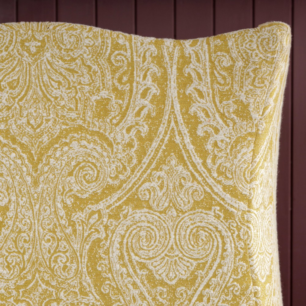 A high-backed Regency wingback armchair upholstered in patterned yellow fabric with turned mahogany front legs on brass castors. View XI