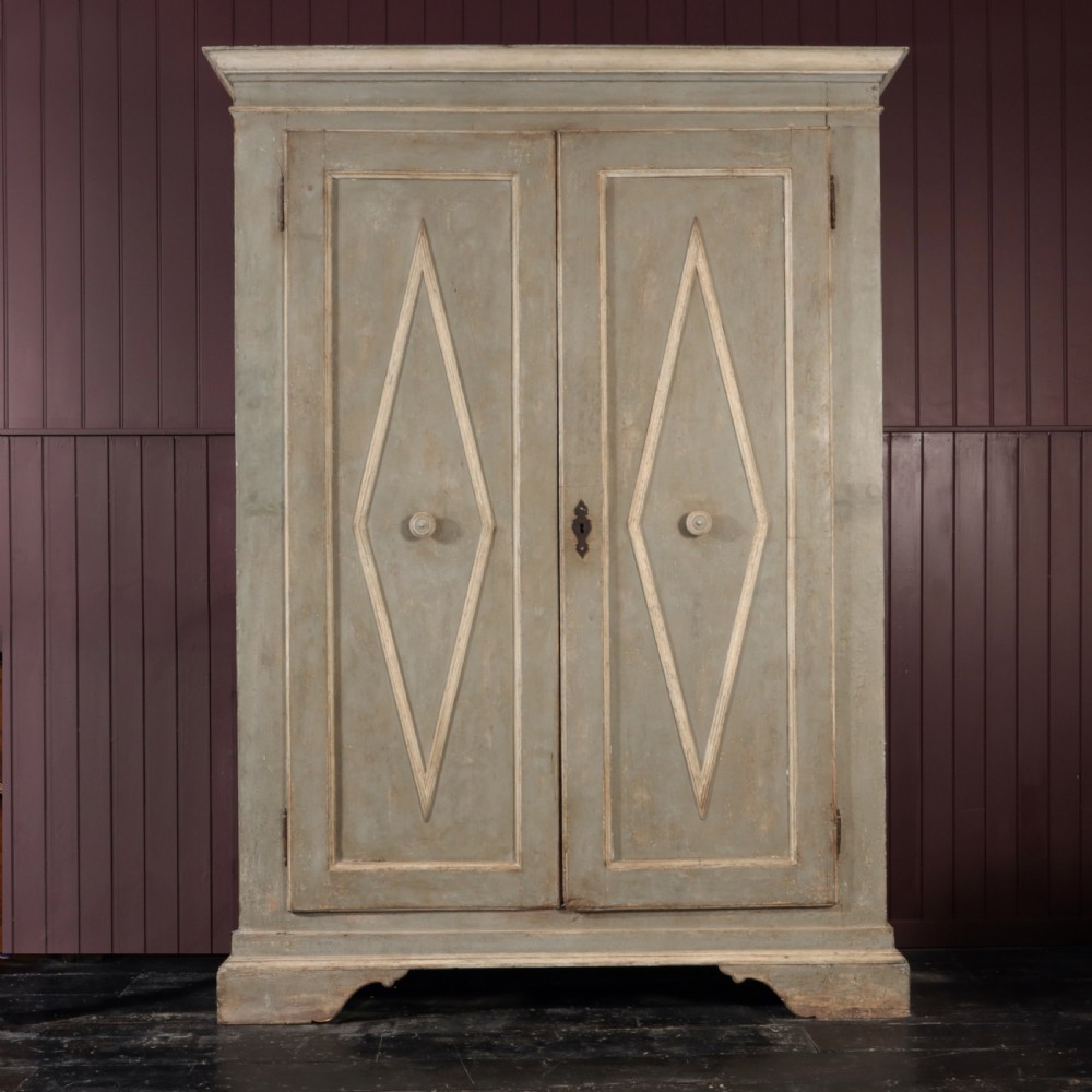 A nineteenth-century Italian painted timber cupboard featuring double doors with raised diamond panel mouldings and a muted grey finish.