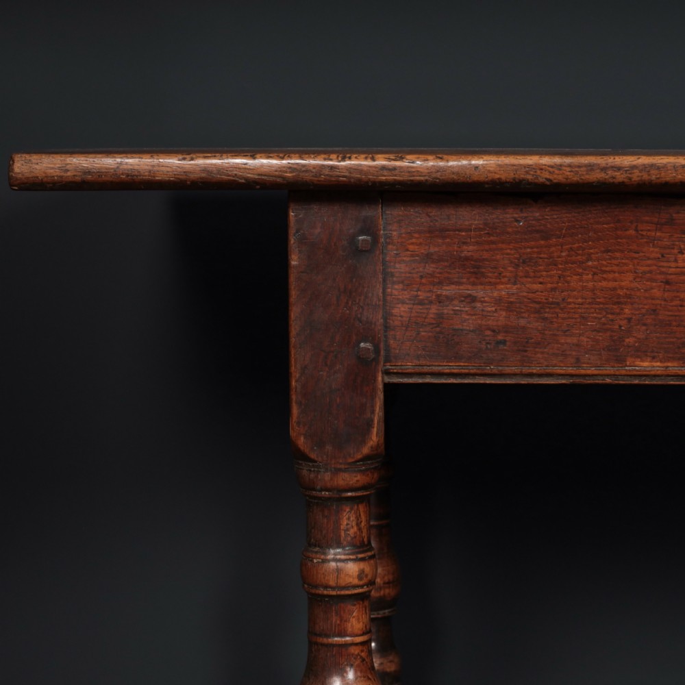 A long 17th-century oak refectory table featuring turned baluster legs, low stretchers, and a thick plank top. View II