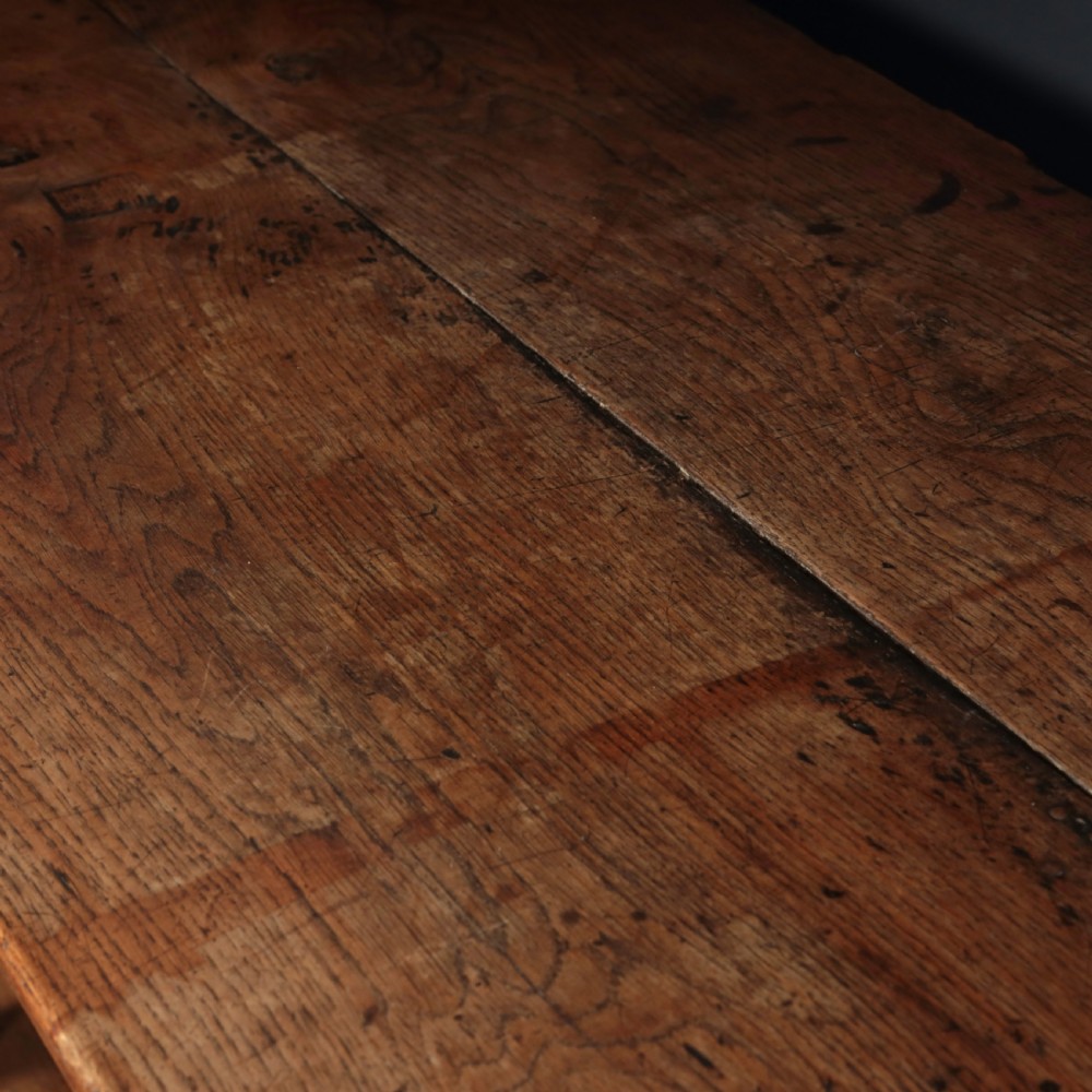 A long 17th-century oak refectory table featuring turned baluster legs, low stretchers, and a thick plank top. View VI