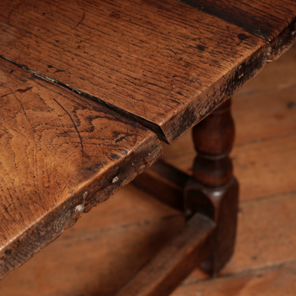 A long 17th-century oak refectory table featuring turned baluster legs, low stretchers, and a thick plank top. View XI