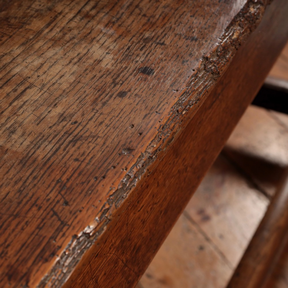 A long 17th-century oak refectory table featuring turned baluster legs, low stretchers, and a thick plank top. View XIV
