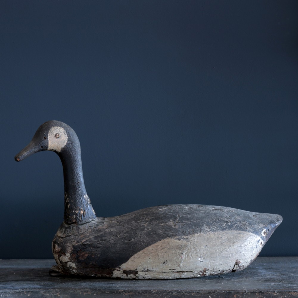 A 19th-century hand-carved wooden Canada goose decoy featuring distressed black and off-white paint with visible wear and natural patina. View II
