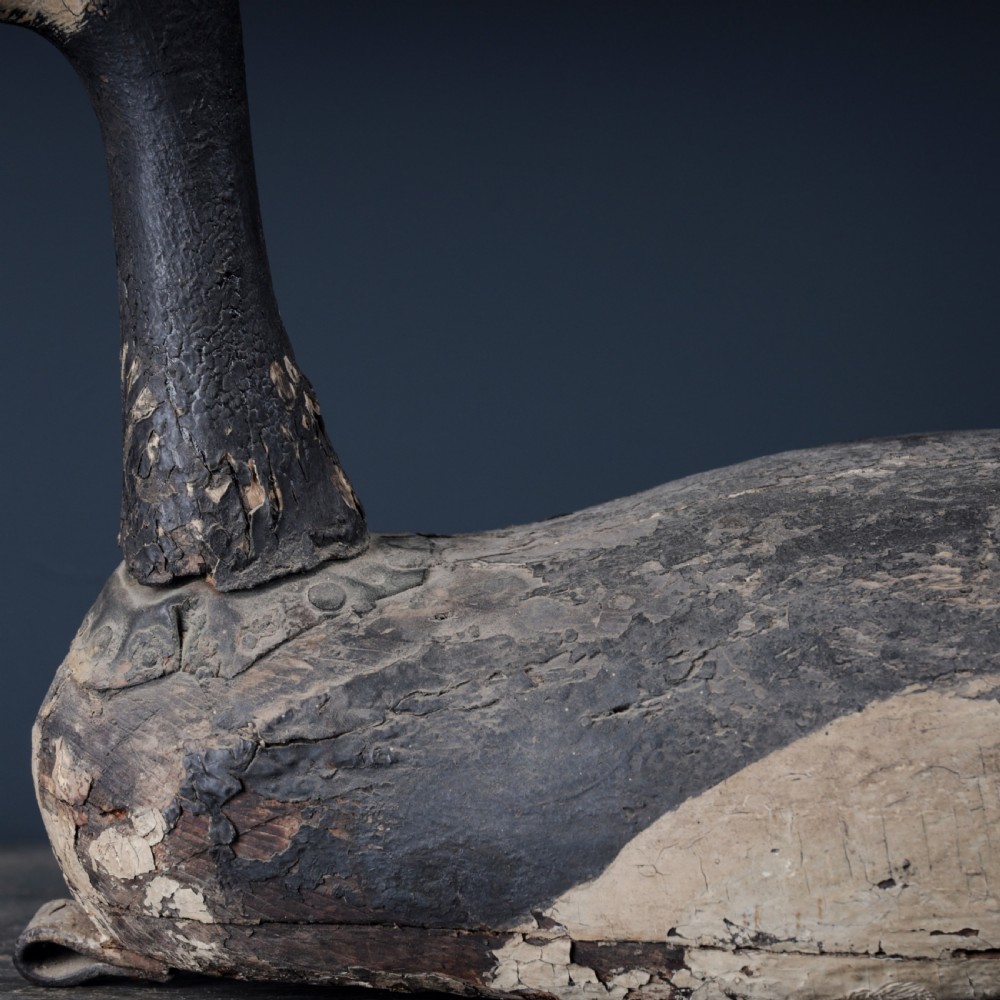 A 19th-century hand-carved wooden Canada goose decoy featuring distressed black and off-white paint with visible wear and natural patina. View III
