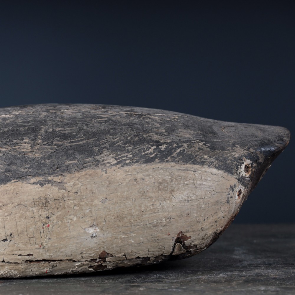 A 19th-century hand-carved wooden Canada goose decoy featuring distressed black and off-white paint with visible wear and natural patina. View VIII