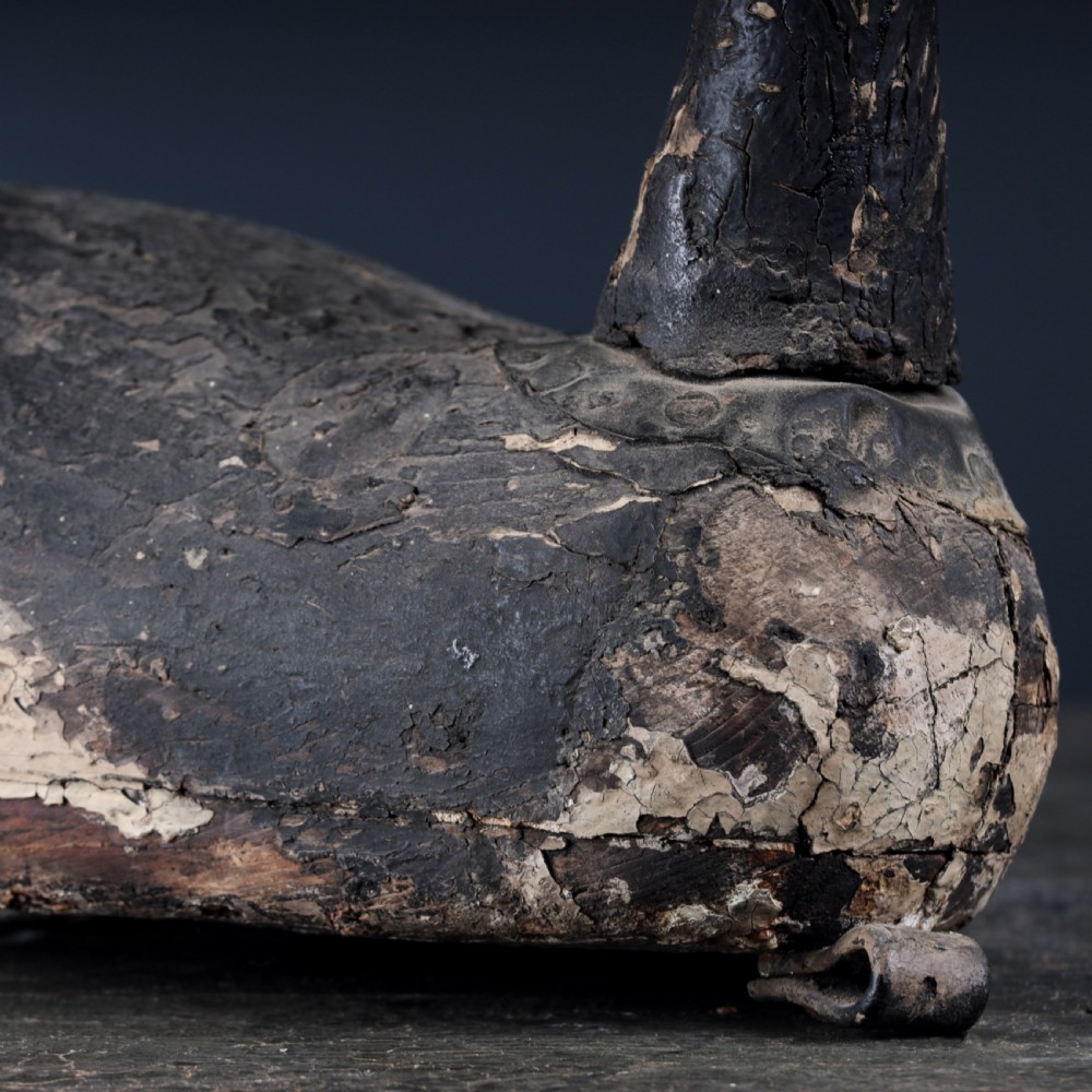 A 19th-century hand-carved wooden Canada goose decoy featuring distressed black and off-white paint with visible wear and natural patina. View X