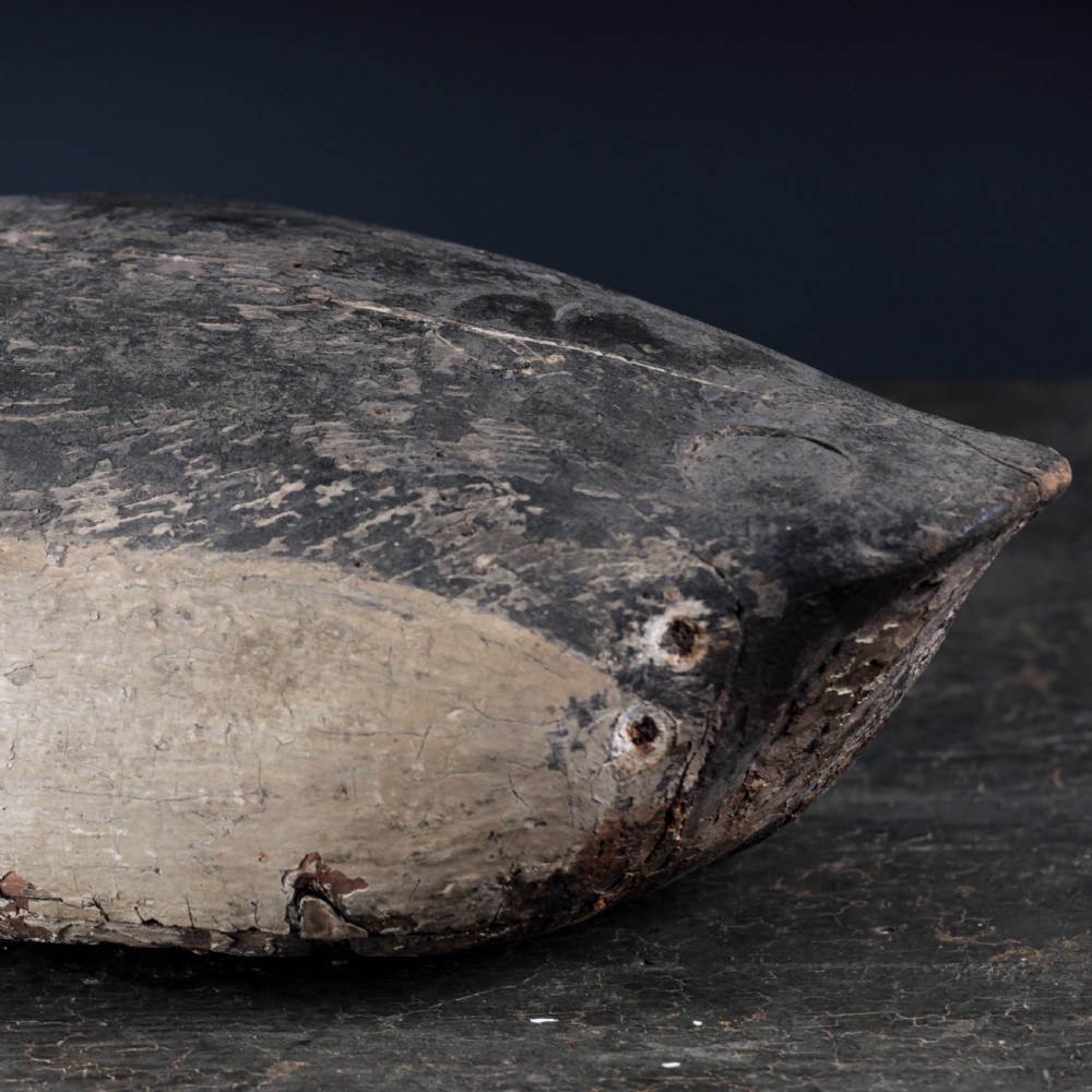 A 19th-century hand-carved wooden Canada goose decoy featuring distressed black and off-white paint with visible wear and natural patina. View XI