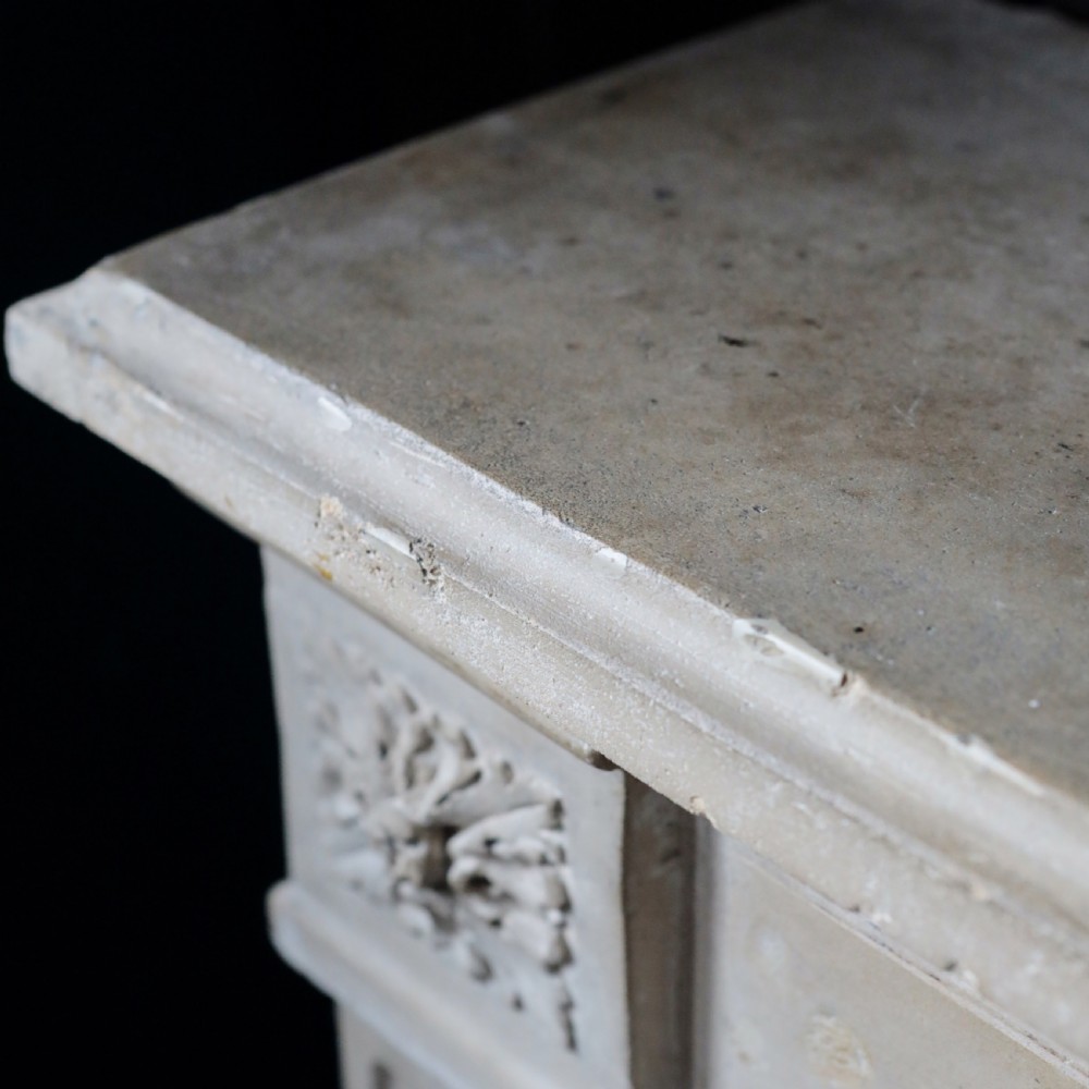 An off-white 18th-century stone fire surround featuring fluted pilasters, floral corner rosettes, and a moulded mantelshelf. View VI