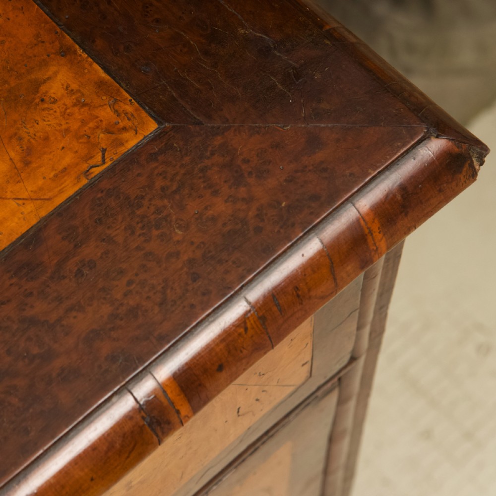 A late 17th-century William and Mary chest of drawers crafted from yew and maple featuring geometric inlaid panels, teardrop brass handles, and turned bun feet. View XI