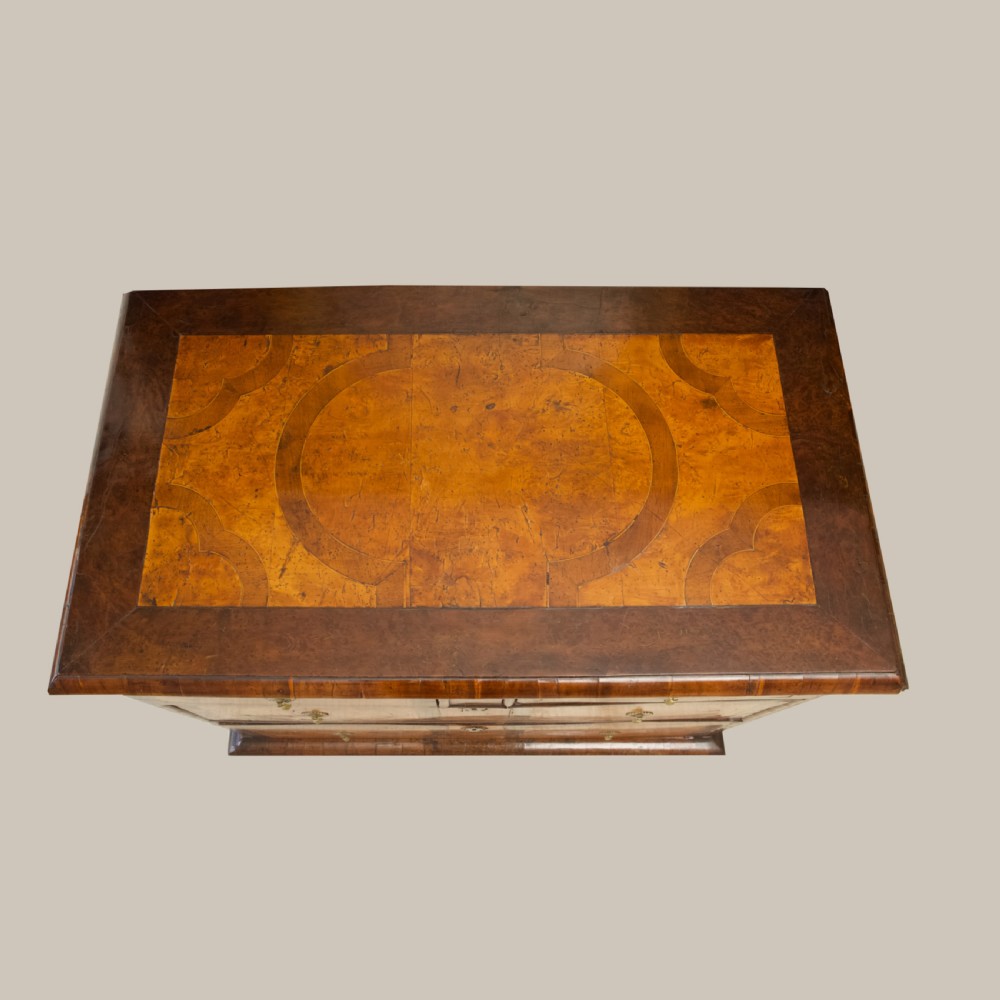 A late 17th-century William and Mary chest of drawers crafted from yew and maple featuring geometric inlaid panels, teardrop brass handles, and turned bun feet. View XIII