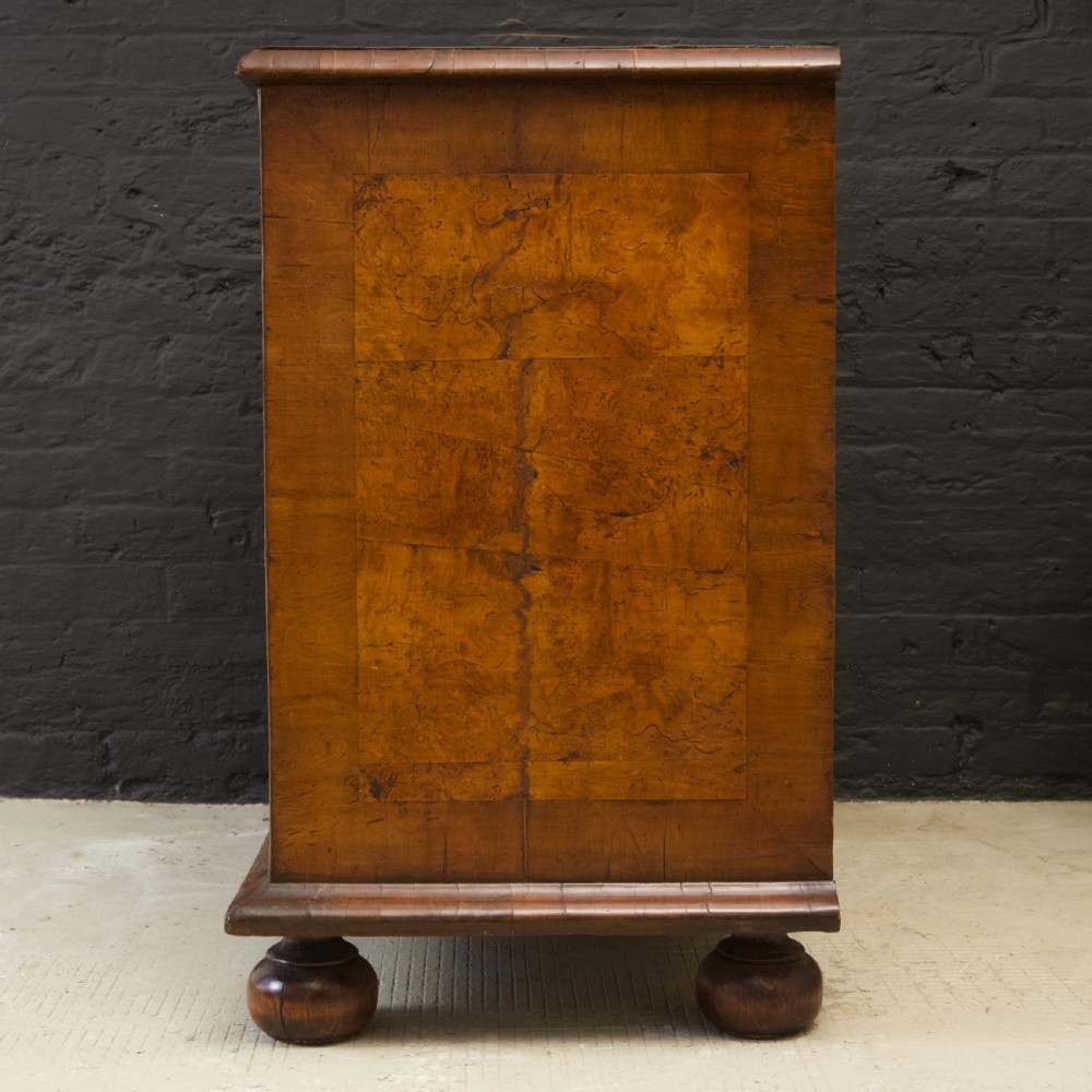 A late 17th-century William and Mary chest of drawers crafted from yew and maple featuring geometric inlaid panels, teardrop brass handles, and turned bun feet. View XV