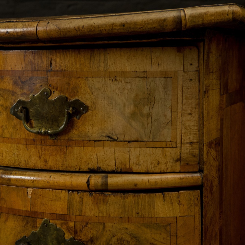 An 18th-century South German walnut chest of drawers featuring a serpentine front, four crossbanded drawers, brass drop handles, and turned bun feet. View III