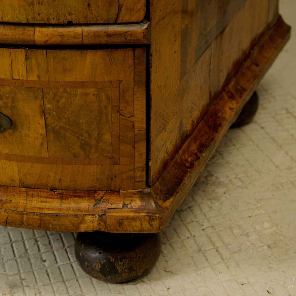 An 18th-century South German walnut chest of drawers featuring a serpentine front, four crossbanded drawers, brass drop handles, and turned bun feet. View VIII