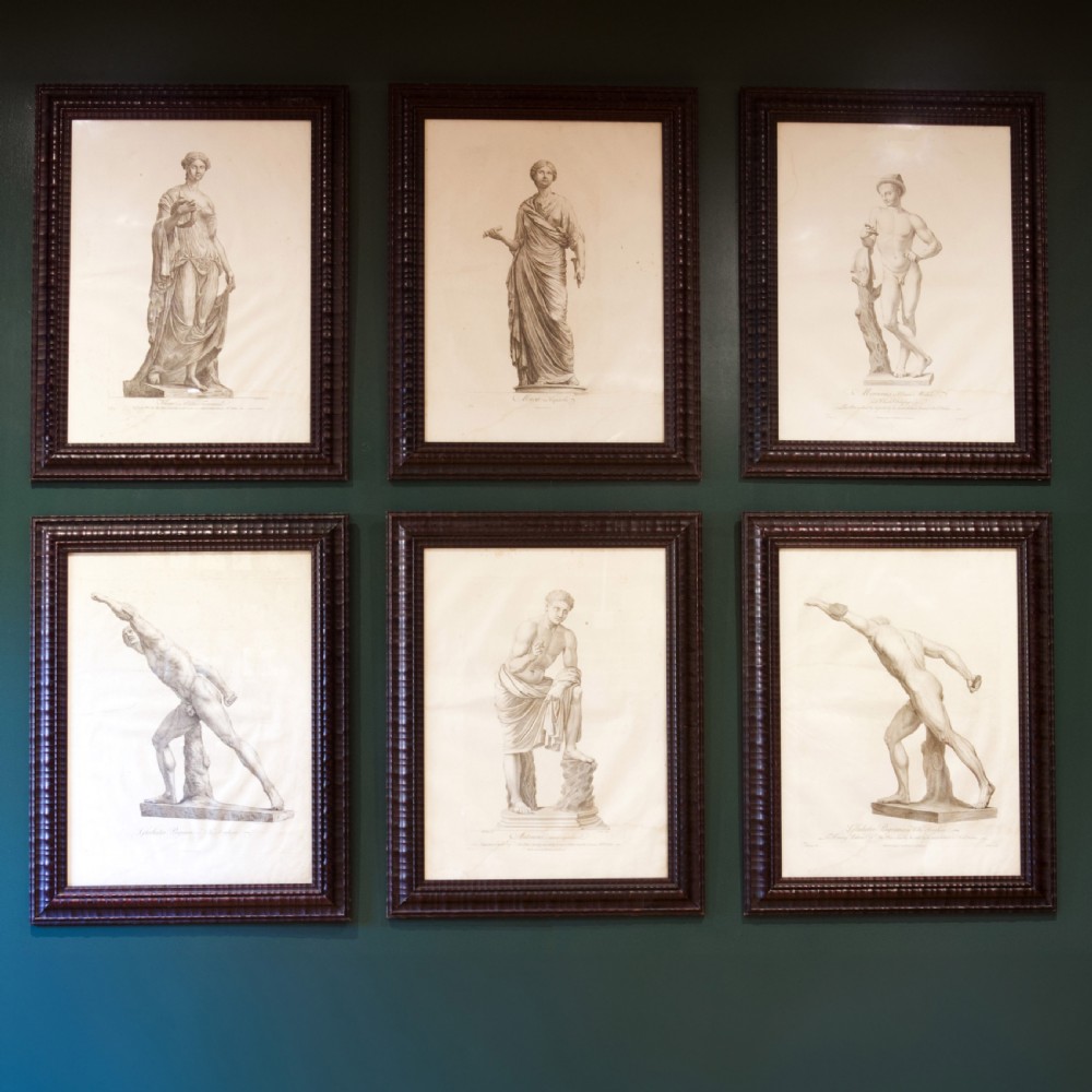 A set of six dark-framed monochrome antique engravings depicting classical statues arranged in two rows.