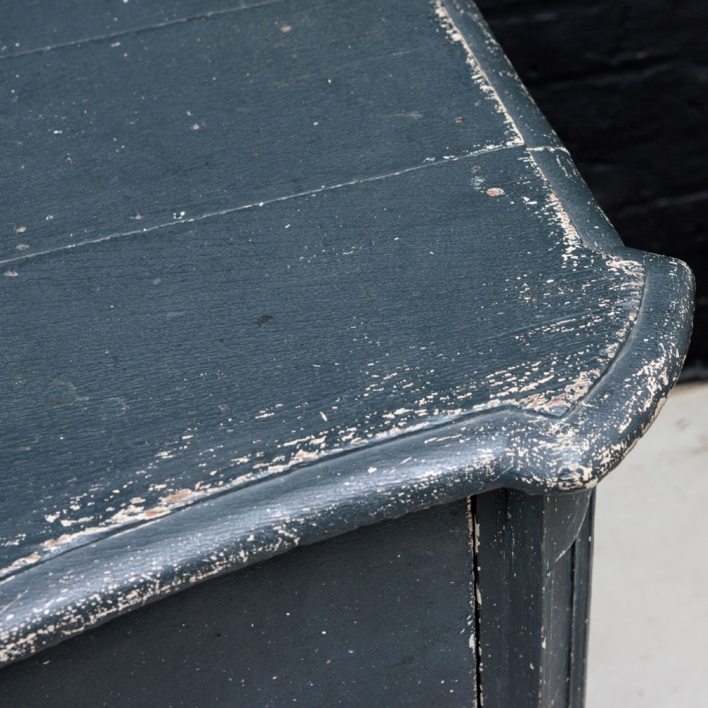An 18th-century dark green painted serpentine-front chest featuring three drawers and detailed brass keyhole escutcheons. View V