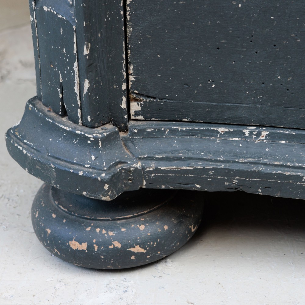 An 18th-century dark green painted serpentine-front chest featuring three drawers and detailed brass keyhole escutcheons. View XV