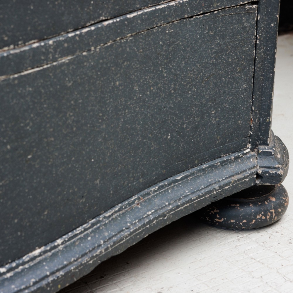An 18th-century dark green painted serpentine-front chest featuring three drawers and detailed brass keyhole escutcheons. View XVI