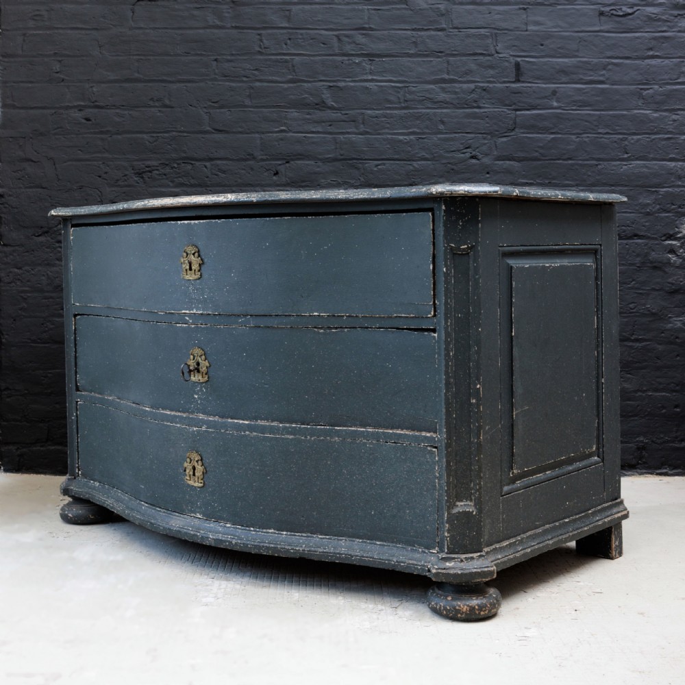 An 18th-century dark green painted serpentine-front chest featuring three drawers and detailed brass keyhole escutcheons. View XVII