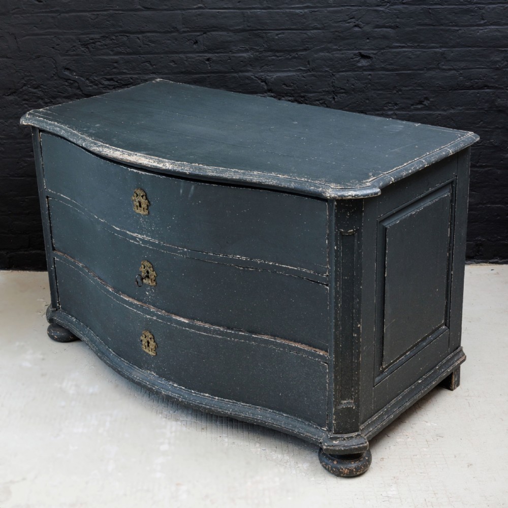 An 18th-century dark green painted serpentine-front chest featuring three drawers and detailed brass keyhole escutcheons. View XVIII