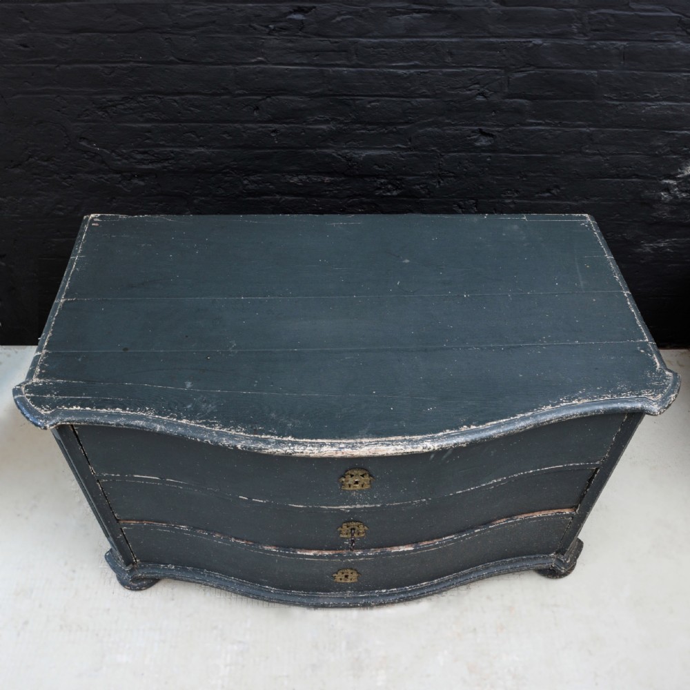 An 18th-century dark green painted serpentine-front chest featuring three drawers and detailed brass keyhole escutcheons. View XXI