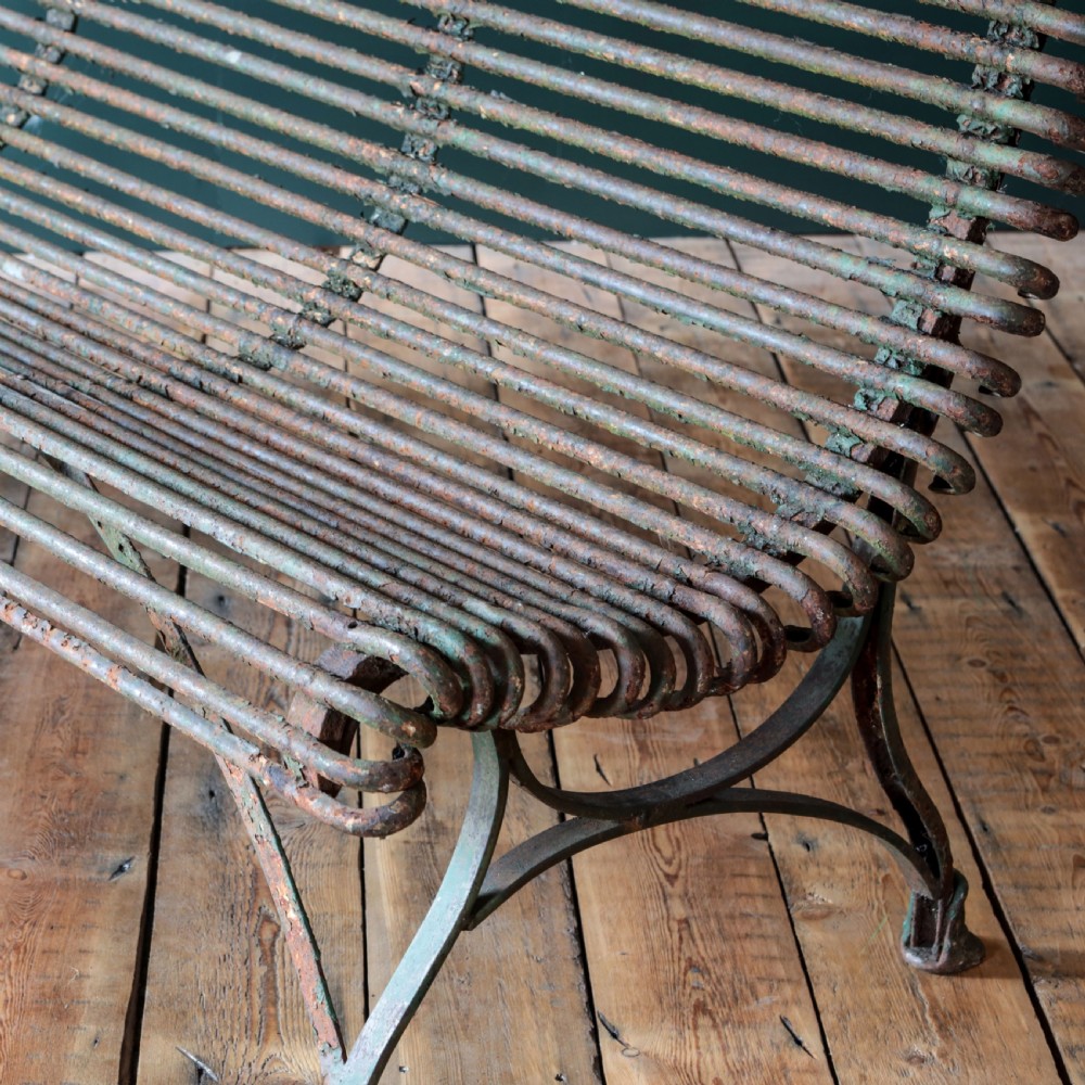 A nineteenth-century French Arras garden bench made of curved green tubular iron slats resting on a riveted iron frame. View XII