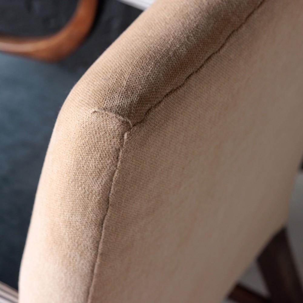 A George II Gainsborough armchair featuring an exposed timber frame, a high beige linen backrest, padded striped armrests, and a deep blue velvet upholstered seat on square legs with brass castors. View IX
