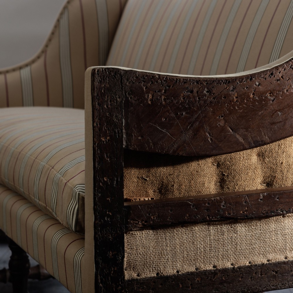 A 17th century wingback sofa featuring striped upholstery, exposed jute side panels, turned wooden legs, and stretchers. View IV