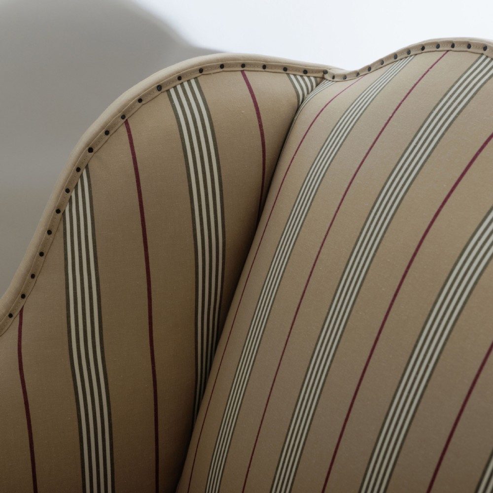 A 17th century wingback sofa featuring striped upholstery, exposed jute side panels, turned wooden legs, and stretchers. View XII