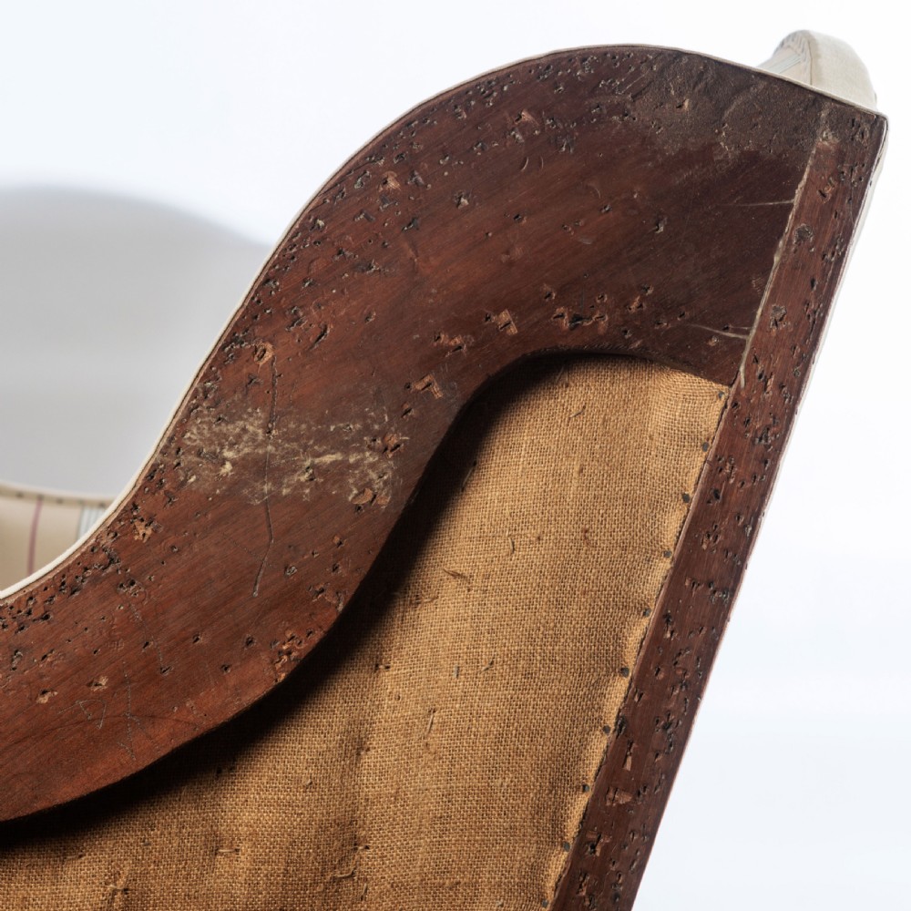 A 17th century wingback sofa featuring striped upholstery, exposed jute side panels, turned wooden legs, and stretchers. View XVIII